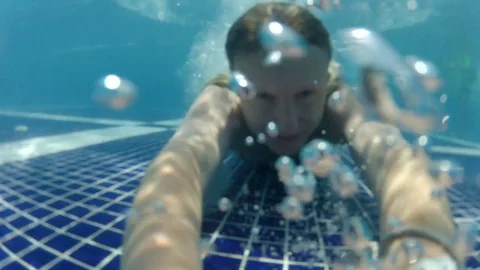 Man jump and dive from side of pool under the water with open eyes Video stock 81359088