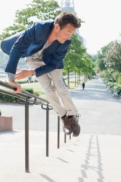 Man jumping across handrail of steps, Eiffel Tower, Paris, Ile-de-France, France Stock Photos