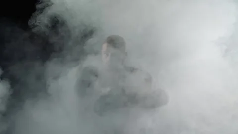 Man jumping and punching, preparing for fight with light and fog around him Stock Footage 315563929