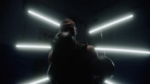 Man jumping around and punching, getting ready to fight with light behind him Stock Footage 315563977