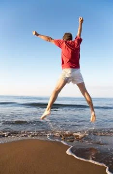 Man jumping on the beach Stock Photos