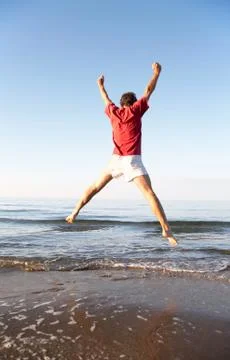 Man jumping on the beach Stock Photos