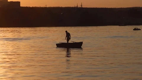 Man jumping from a boat at sunset Stock Footage 88186538