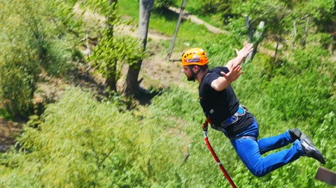 A man jumping from the bridge facing forward his arms to the sides Stock Footage 50753419