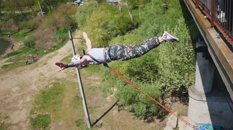 A man jumping from the bridge facing forward hands wide apart Stock Footage 68351610