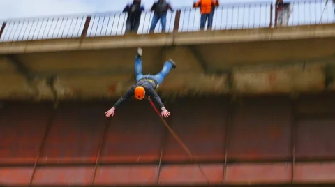A man jumping off a bridge in full view of friends Stock Footage 49923083