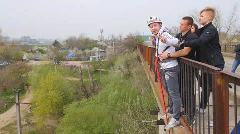 A man jumping off a bridge with the help of an instructor Stock Footage 68350528