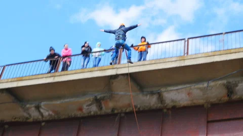 A man jumping off a bridge his arms and legs Stock Footage 49923191