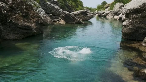 Man jumping into the canyon river with crystal clear blue water for refreshing Stock Footage 247402453