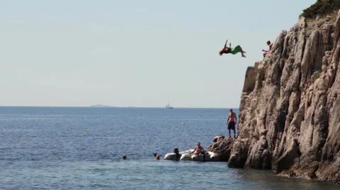 Man jumping of the cliff into the ocean double Backflip Stock Footage 49091833