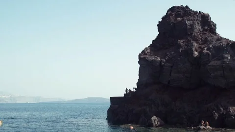 Man jumping off cliff into the ocean. Summer fun lifestyle. Stock Footage 106346089