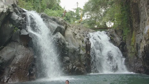 Man jumping off from a cliff into the plunge pool Stock Footage 87142232