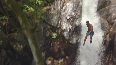Man jumping off from a cliff into the water Stock Footage 87143130
