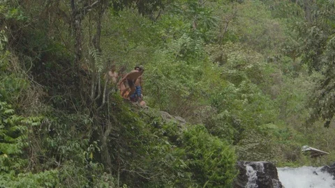 Man jumping off from a cliff into the water Stock Footage 87143649