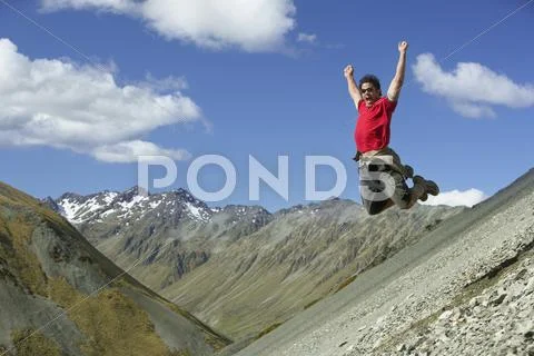 Man Jumping Down Rocky Slope Stock Photos