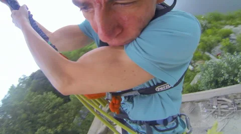 Man jumping forward facing clawing rope Stock Footage 48358224
