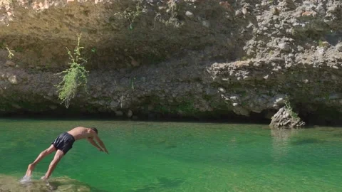 Man jumping headfirst into crystal clear water in the river. Stock-Footage 158803651