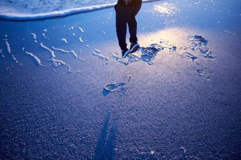 Man jumping for joy on a beach at sunset Foto stock