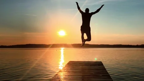 Man jumping into the lake Stock Footage 95390199