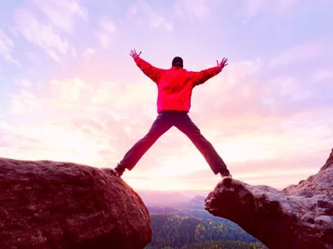 Man jumping from the mountain edge.  Man jumping off a cliff without rope. Ri Foto stock