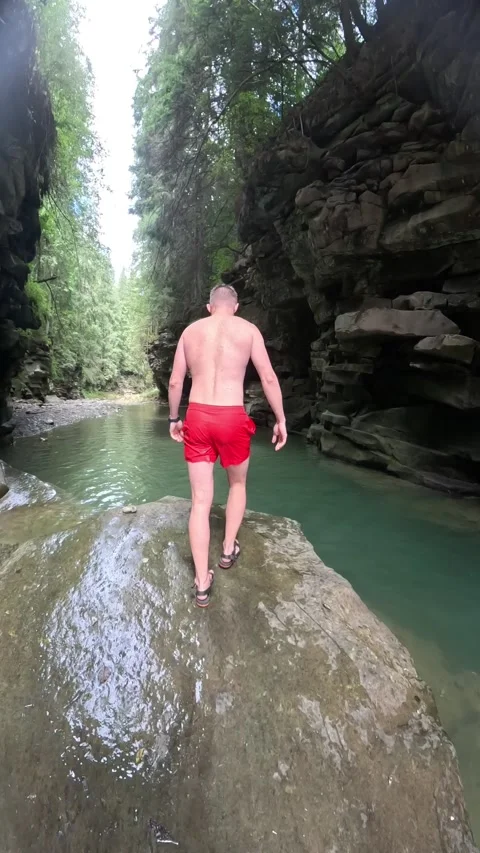 Man jumping into mountain river in canyon Stock Footage 261014811