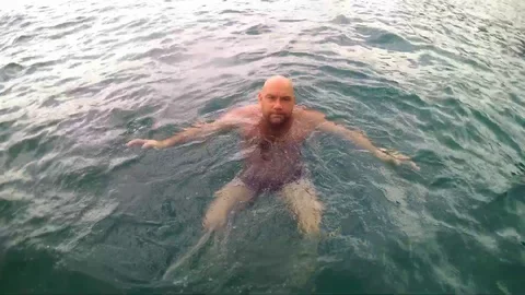 Man jumping into ocean. 库存影片 99813996
