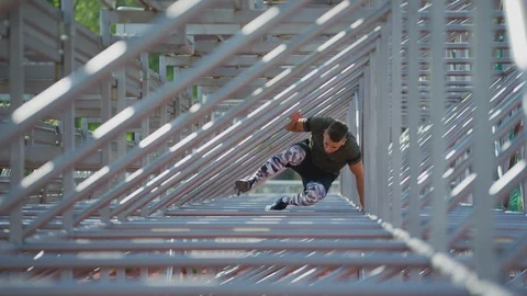 Man jumping over metallic bars Stock Footage 100034637