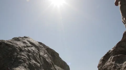 Man jumping over rocks against the sky Stock Footage 61748483