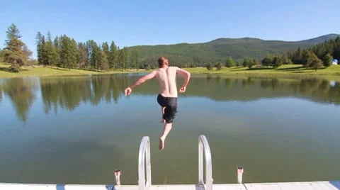 Man jumping into pond slow motion Stock Footage 8575707