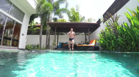 Man jumping into the pool Видео 50864260