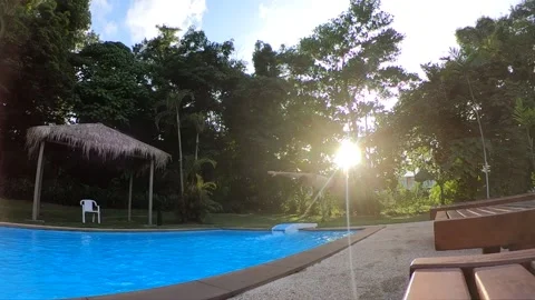 Man jumping into the pool at sunset, slow motion video Stock Footage 164921084