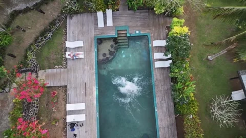 Man jumping to the pool, while drone rise up. Vacation scene from Fiji, Pacific Stock Footage 336489638