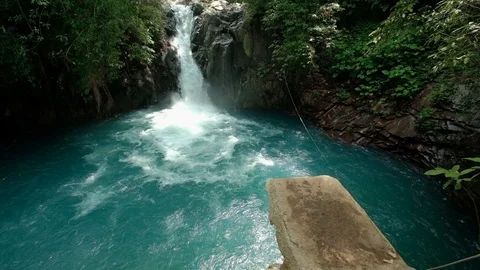 Man jumping in the river with waterfall slow mo Stock Footage 88125746