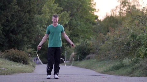Man jumping rope in the park Stock Footage 82063296