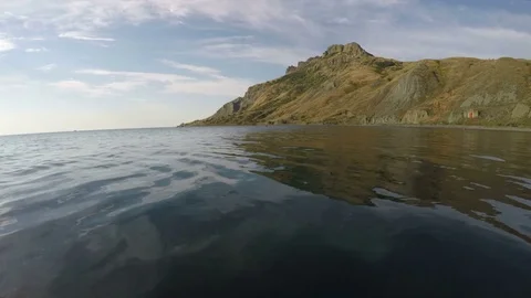 Man jumping into the sea against the background of mountains 스톡 동영상 79254075