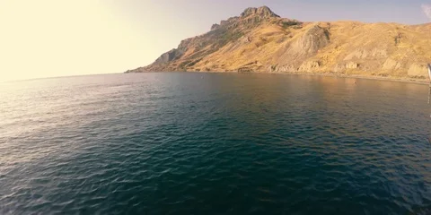 Man jumping into the sea against the background of mountains Video stock 84549341
