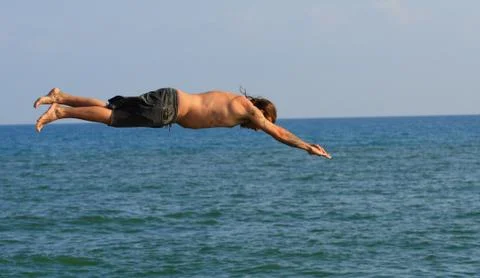 Man jumping into the sea Stock Photos