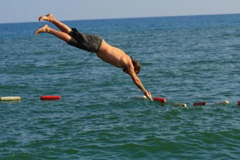 Man jumping into the sea Stock Photos