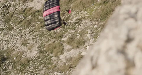 Man jumping off seacoast cliffs and deploying parachute to land on beach Video stock 160504081