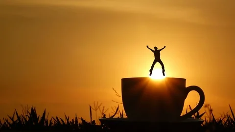 A man jumping slow motion on a coffee cup. sunset and cloud sky time lapse. Stock Footage 107402586