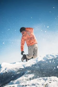 A man is jumping on top of a mountain Stock Photos