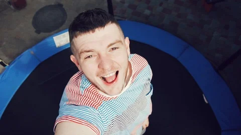 A man is jumping on a trampoline. He is happy. Fun. Slow motion. Stock-Footage 89841795