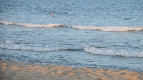 Man jumping waves at beach sunset pink Video stock 94821683