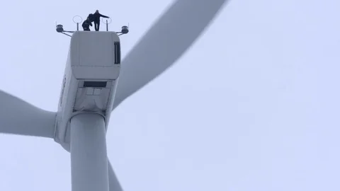 Man jumping from windmill with parachute Stock Footage 74908397