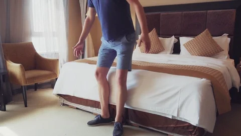 A man jumps on the bed. Stock Footage 98849126