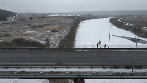 A man jumps from a bridge on which vehicles are moving through, rope jumping Stock Footage 172230648