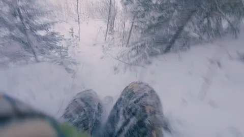A man jumps down from a high bank in the forest in winter. Stock-Footage 323296837
