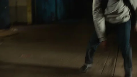 Man jumps down from a ledge and rolls on the floor to break his fall in dirty wa Video stock 199459109