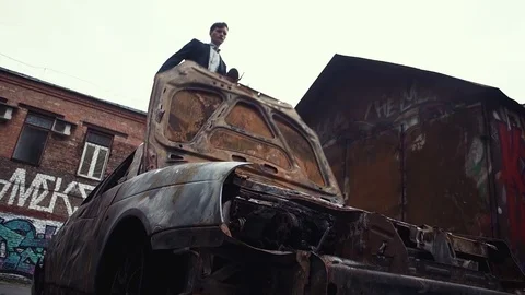 Man jumps down from top of car. Unidentifiable graffiti on the walls Stock Footage 80008885