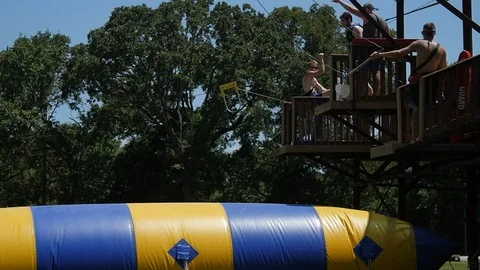 Man jumps on giant inflatable in slow motion Video stock 118721990
